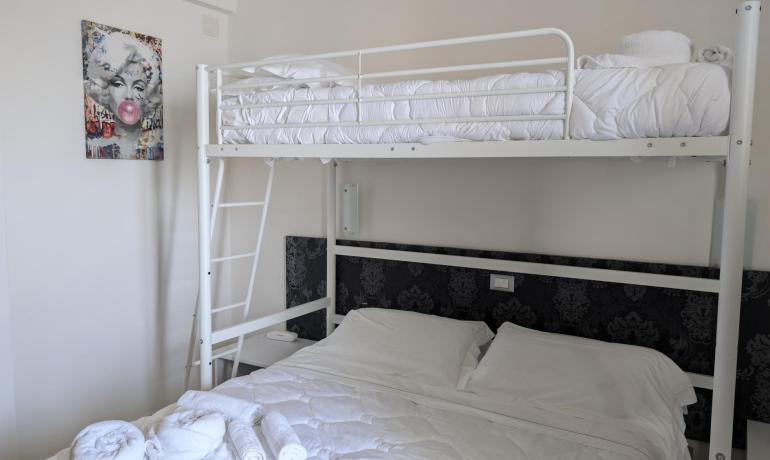 Camera moderna con letto a castello, arte pop e atmosfera accogliente.