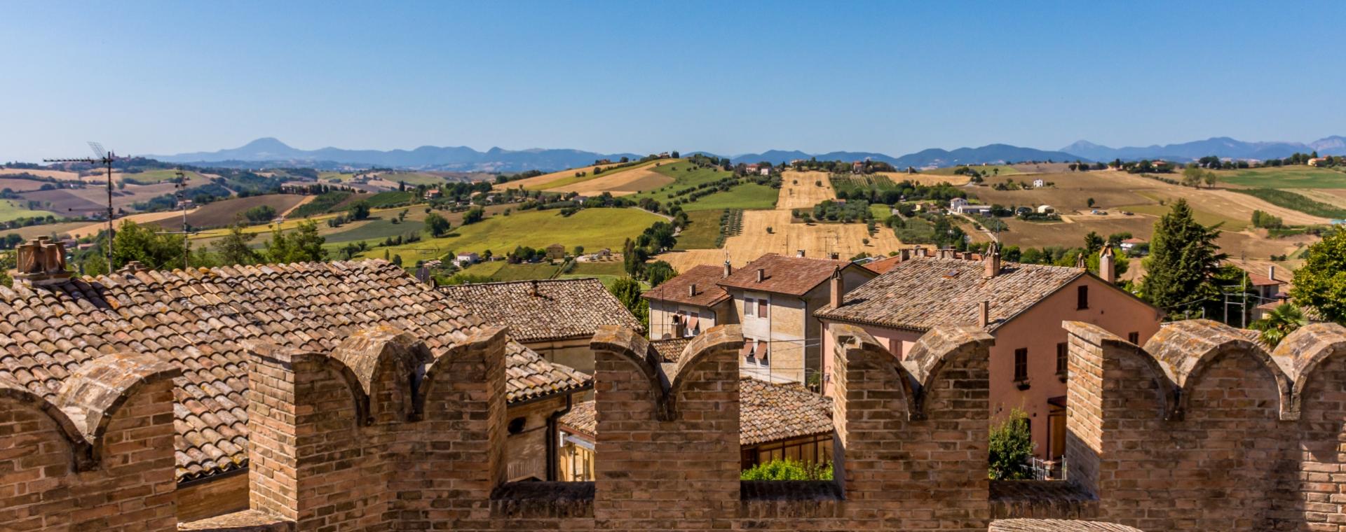 Hilly landscape with rooftops and brick walls.