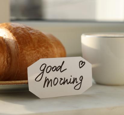 Croissant et café avec note 'bonjour'.