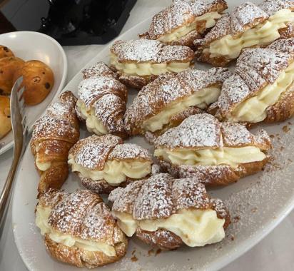 Croissants à la crème avec sucre glace sur une assiette.