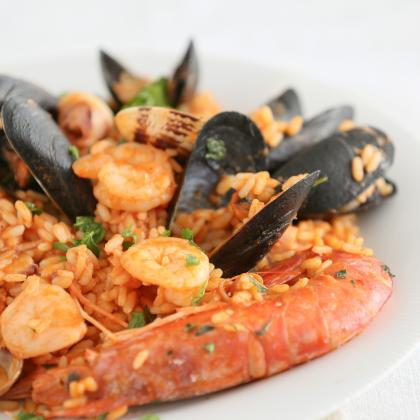 Paella di mare con gamberi, cozze e riso speziato.