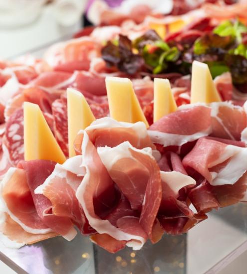 Tagliere di salumi e formaggi con prosciutto e formaggio a fette.